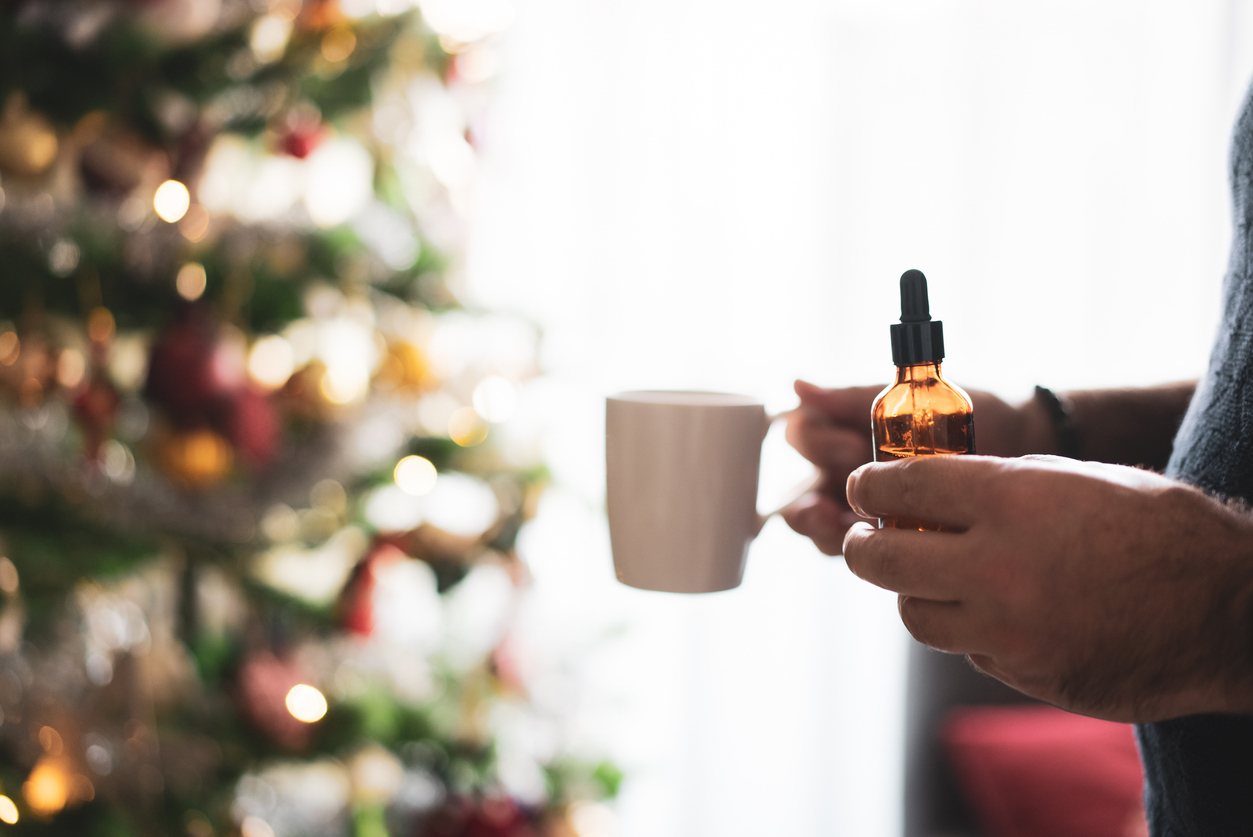 A cropped photo of a man enjoying cannabis oil during the holiday season.