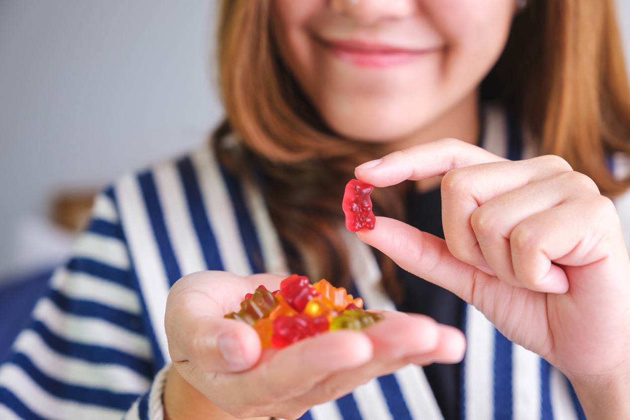 Relieving holiday stress - A woman holding colorful CBD gummies in her hands.