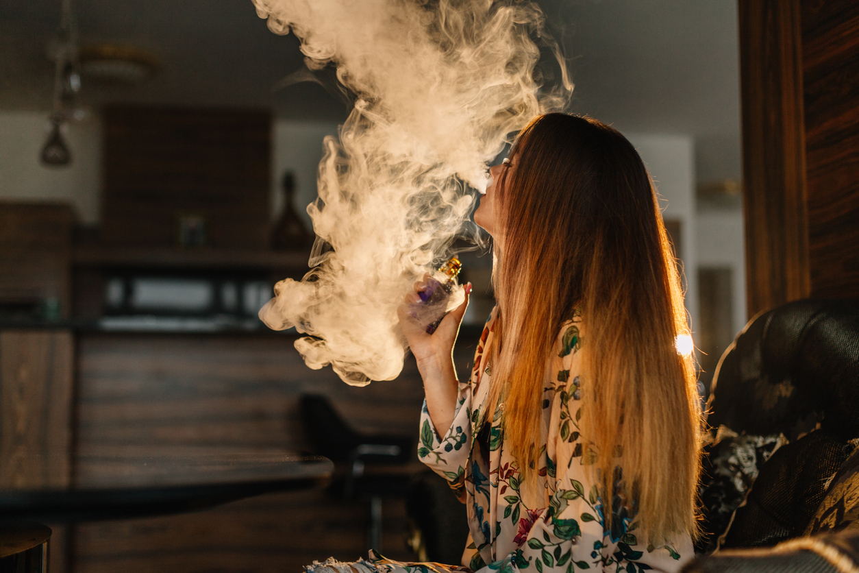 Vaporizing cannabis - A woman vaping cannabis at home.